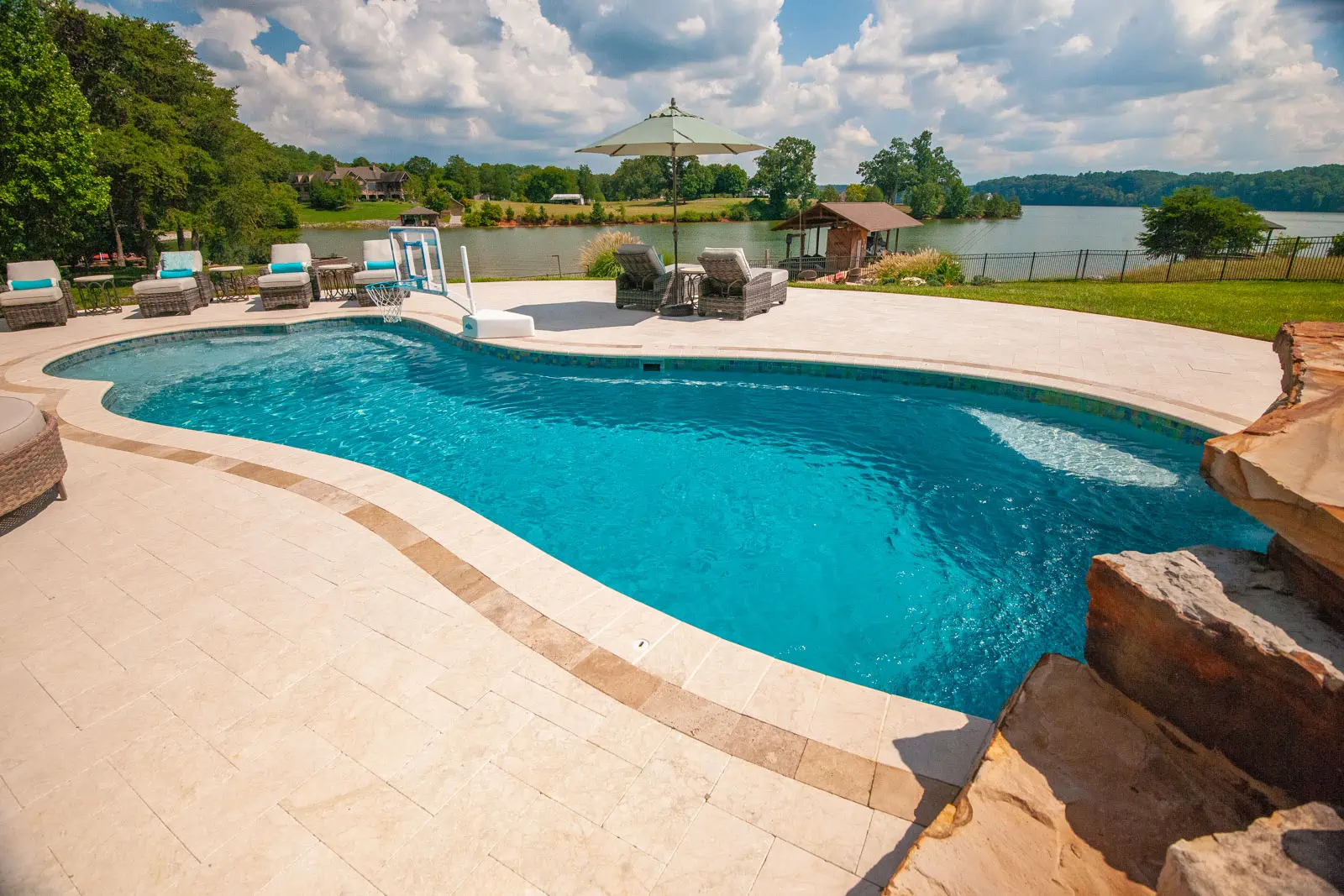 side view of irregular shape fiberglass pool in backyard by pools by design